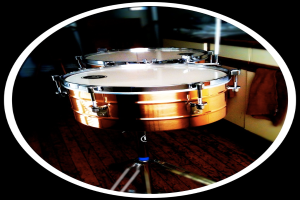 Eine Vielzahl von Musikinstrumenten ist auf einem Holzboden angeordnet.