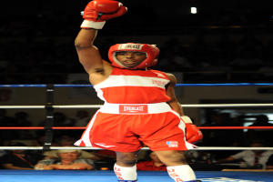 Ein Mann in einem Boxring mit Boxausrüstung, Helm und Handschuhen, mit Zuschauern im Hintergrund.