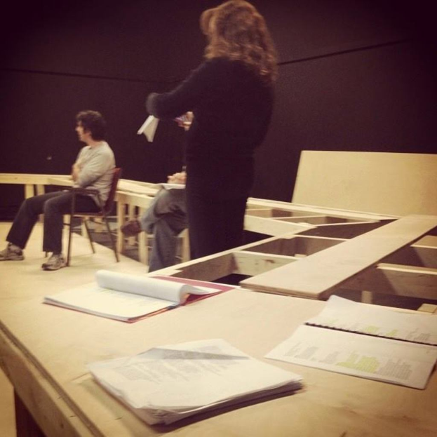 Drei Personen neben einer Sammlung von Büchern.