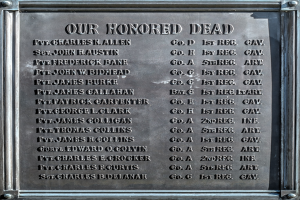 Gedenktafel an einem Gebäude mit der Inschrift "Unseren Ehrenvollen Toten" in Metallbuchstaben.