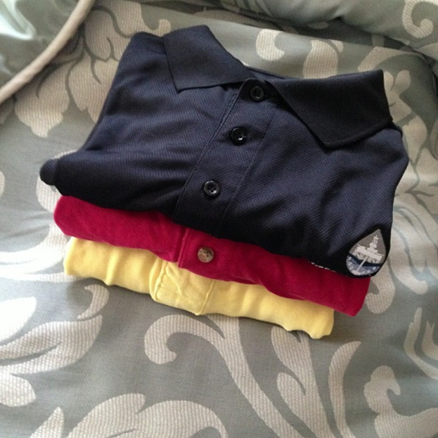 Polo-T-Shirts werden mit Stoff im Hintergrund angezeigt.