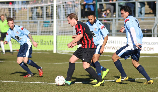 Eine Gruppe von Menschen beim Fußballspielen auf einem Feld.