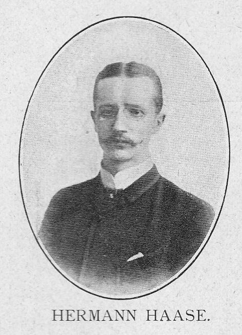 Schwarzes und weißes Porträtfoto des deutschen Komponisten und Pianisten Hermann Haase in einem Anzug mit Schnurrbart und ernstem Gesichtsausdruck, mit deutschem Text unten.