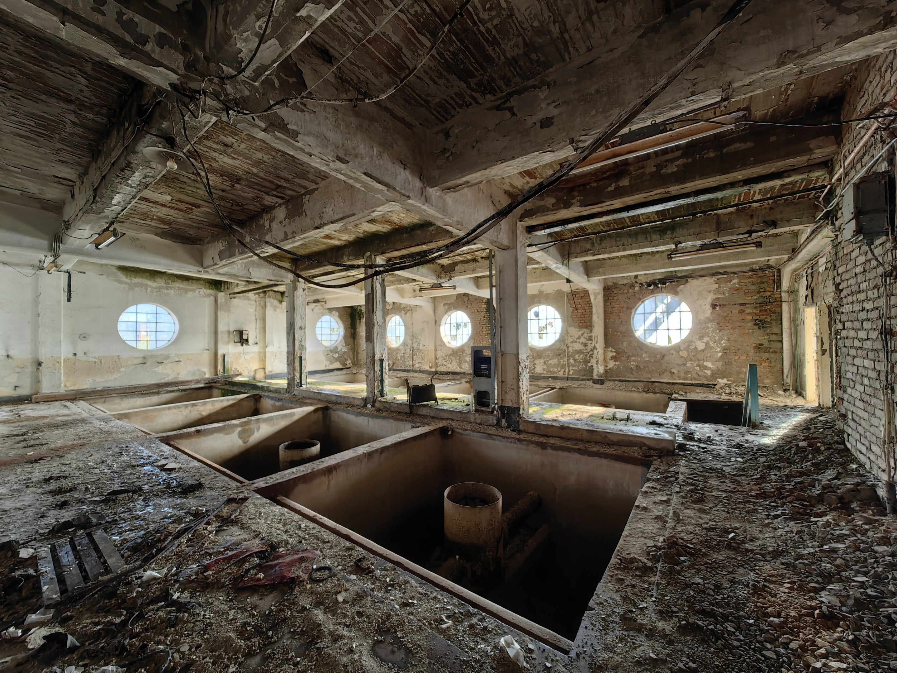 Verlassenes Gebäude im Inneren der Sperrzone von Tschernobyl mit verstreuten Trümmern, freiliegenden Wänden, Decke und strukturellen Elementen.