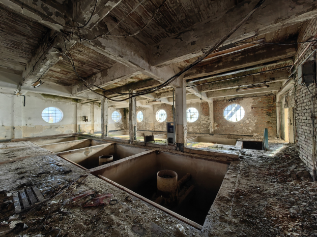 Verlassenes Gebäude im Inneren der Sperrzone von Tschernobyl mit verstreuten Trümmern, freiliegenden Wänden, Decke und strukturellen Elementen.