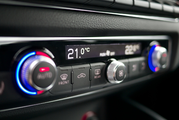 Eine Bedienkonsole mit mehreren Knöpfen, Reglern und Leuchten, die einen Text in der Mitte zeigt.