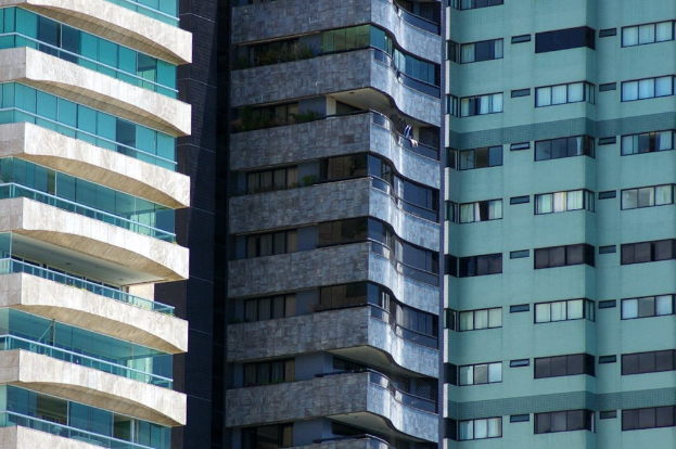 Verschiedene Gebäude mit unterschiedlichen Höhen und Designs sind in einer städtischen Umgebung zu sehen.