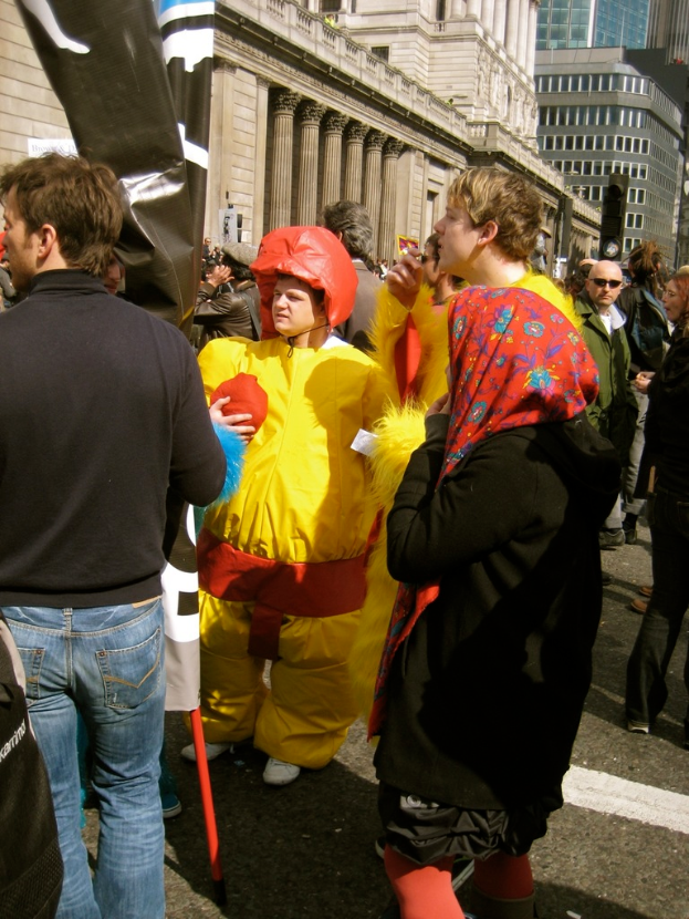 Ein Clown steht in der Mitte des Bildes, mit Menschen auf der linken und rechten Seite und Geb├Ąuden ├╝berall.