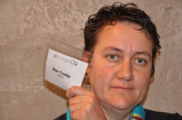 Eine Person in einem schwarzen Kleid hält eine Karte in der Hand.