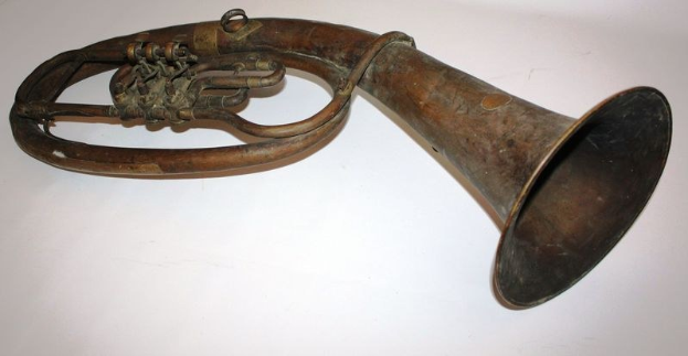 Alter Messinghorn mit glänzendem Finish, gebogener Hals und aufgeweiteter Schalltrichter, verziert mit kunstvollen Gravuren, auf einem weißen Hintergrund.