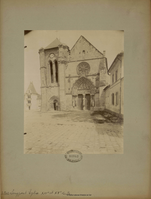 Ein altes Foto einer Kirche in der Mitte einer Straße, gerahmt in einem Fotorahmen, umgeben von anderen Gebäuden in einer belebten Stadtkulisse.
