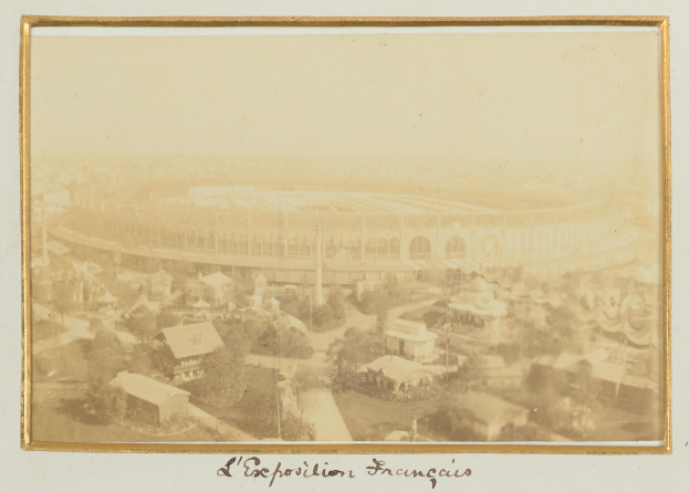 Altes Schwarz-Wei├č-Foto eines Stadions in einer urbanen Umgebung, umgeben von Geb├Ąuden, B├Ąumen und Strommasten, mit Text am unteren Rand.