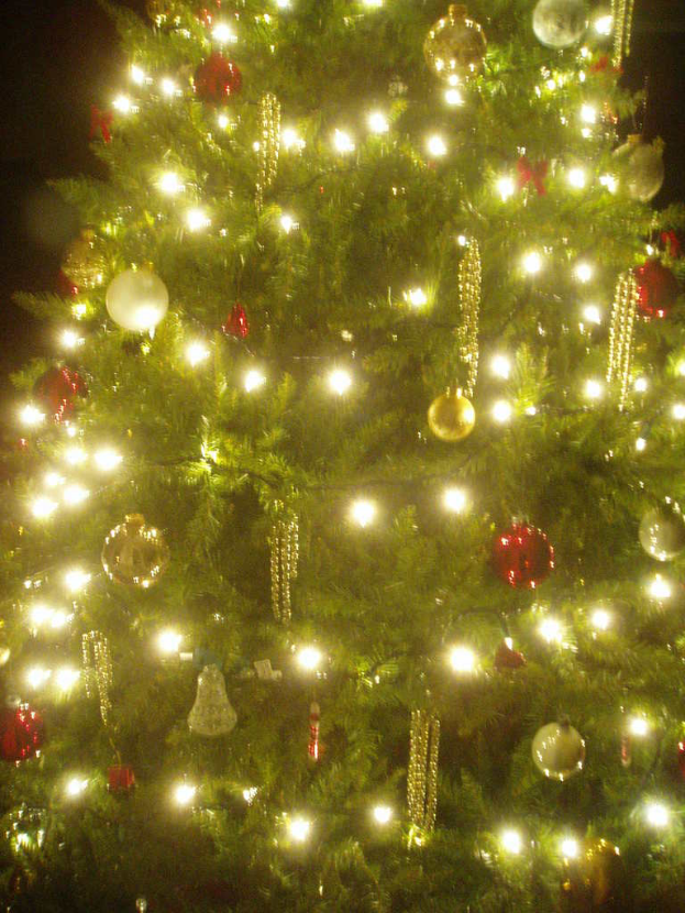 Ein Weihnachtsbaum, geschmückt mit Lichtern, Kugeln und anderen Schmuckstücken.