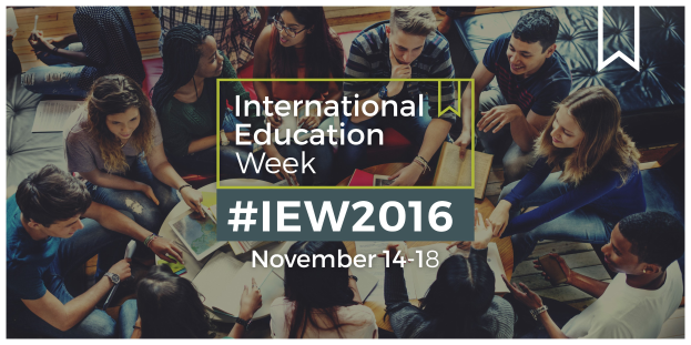 Eine Gruppe von Menschen, die auf einem Sofa sitzen, einige halten Bücher und Stifte, mit dem Text 'International Education Week IEW 2016' in der Mitte, die scheinbar über das Thema diskutieren.