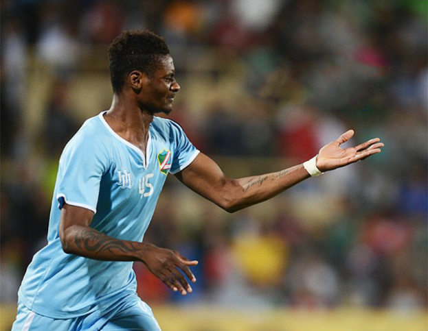 Ein Fussballspieler in einem blauen Trikot feiert nach einem Tor mit ausgestreckten Armen.