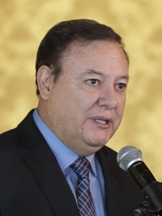 Ein Mann im Anzug und Krawatte spricht in ein Mikrofon, identifiziert als Generalstaatsanwalt.