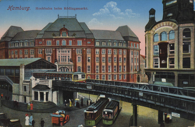 Ein altes Postkartenmotiv zeigt einen Bahnhof in Hamburg, Deutschland, mit Menschen, Fahrzeugen, Gebäuden, einer Brücke und einem bewölkten Himmel sowie Text oben drauf.