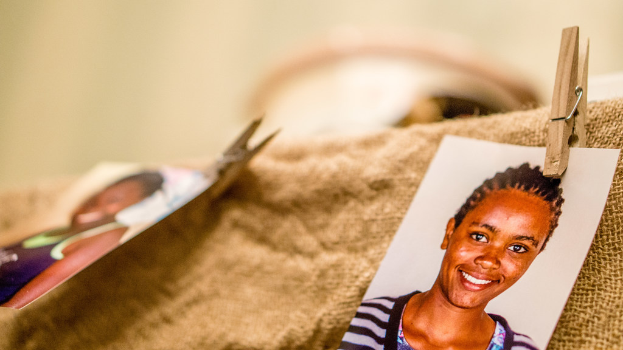 Rechts befindet sich eine Büroklammer, ein Passfoto im Passformat und ein Stoffstück. Die linke Seite und der Hintergrund sind unscharf.