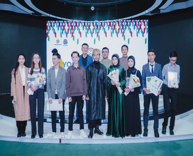Gruppe von Menschen auf einer Bühne mit Blumensträußen und Urkunden, vor dem Hintergrund "Jugendsonnenpreis 2019"